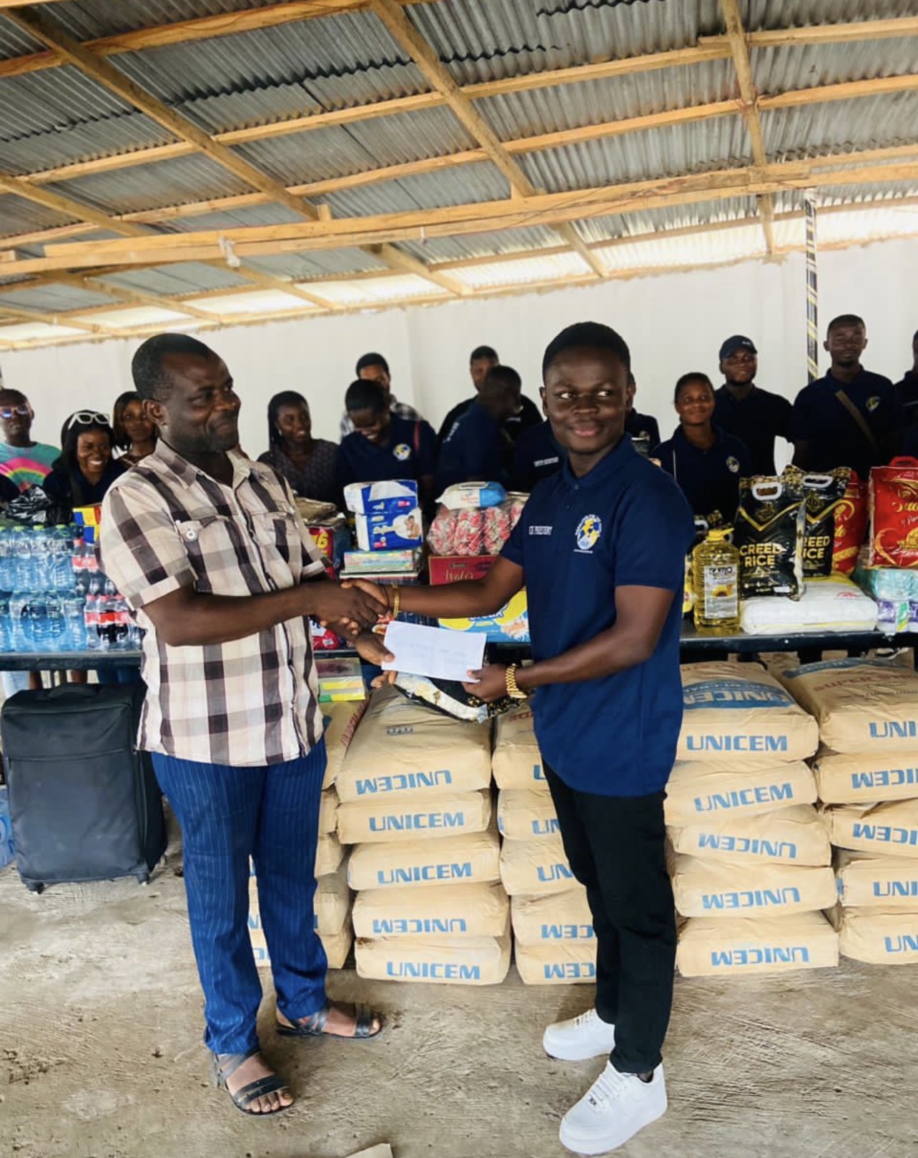 IWF representative presenting donated provisions to an orphanage home leader